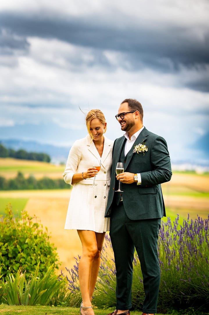 Couple de mariés dans la campagne vaudoise au coucher du soleil | Photographe mariage Vaud naturel et lumineux