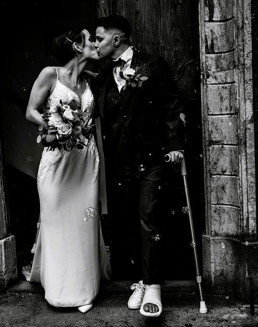 Sortie des mariées du château de Monthey en Valais, en noir et blanc, moment d’amour et de liberté immortalisé par le photographe Dis-moi Oui.