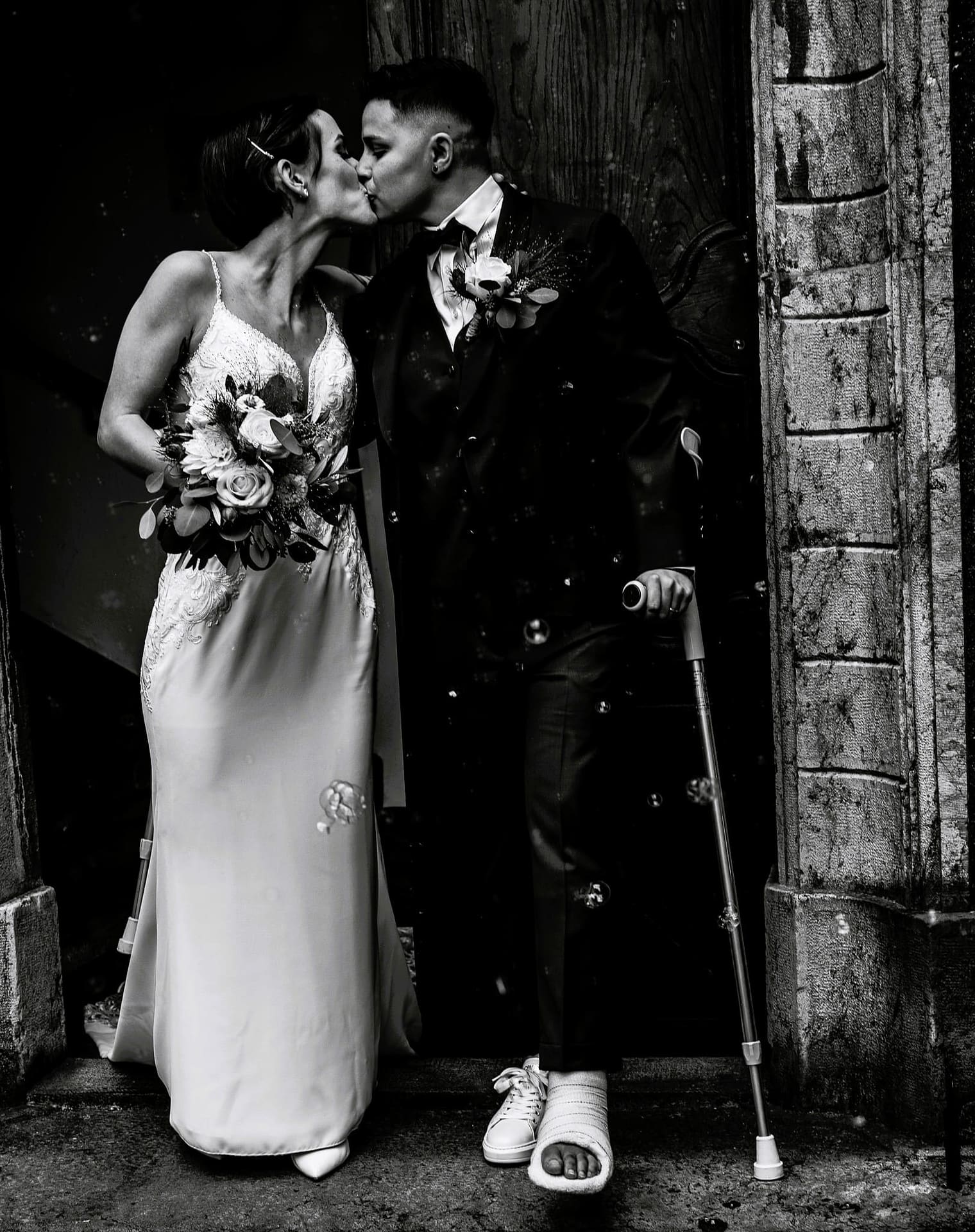 Sortie des mariées du château de Monthey en Valais, en noir et blanc, moment d’amour et de liberté immortalisé par le photographe Dis-moi Oui.